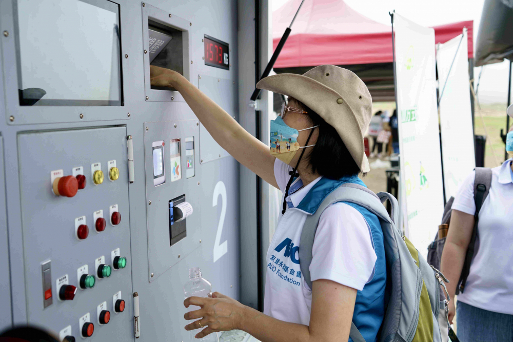 志工們將拾起的寶特瓶投入「好歸塑專車」，讓廢棄塑料空瓶可以直接粉碎、縮小體積，未來將可再製成購物袋、寶特衣、悠遊卡等生活用品